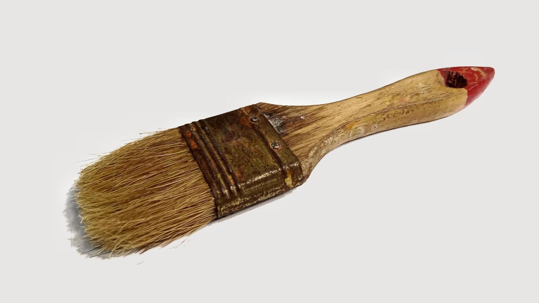 Vintage paintbrush with worn bristles and wooden handle. Concept of DIY, renovation, art, craft, and restoration. photo