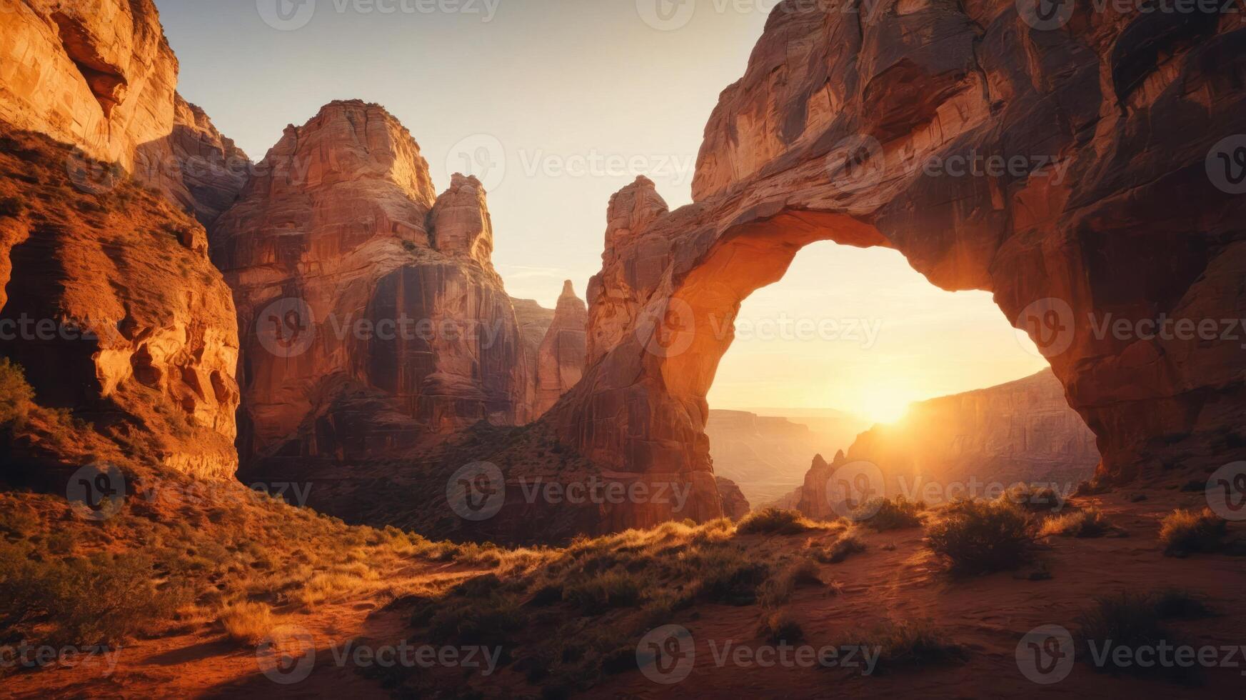 A stunning sunset view through a natural rock arch in a desert landscape. photo