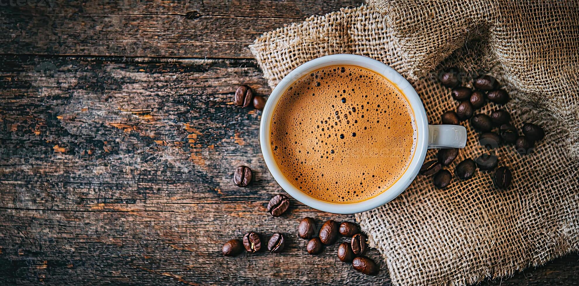 Coffee cup with steam and coffee beans on a wooden background. A cup of hot espresso or black latte, with a burlap sack on an old, rustic table photo