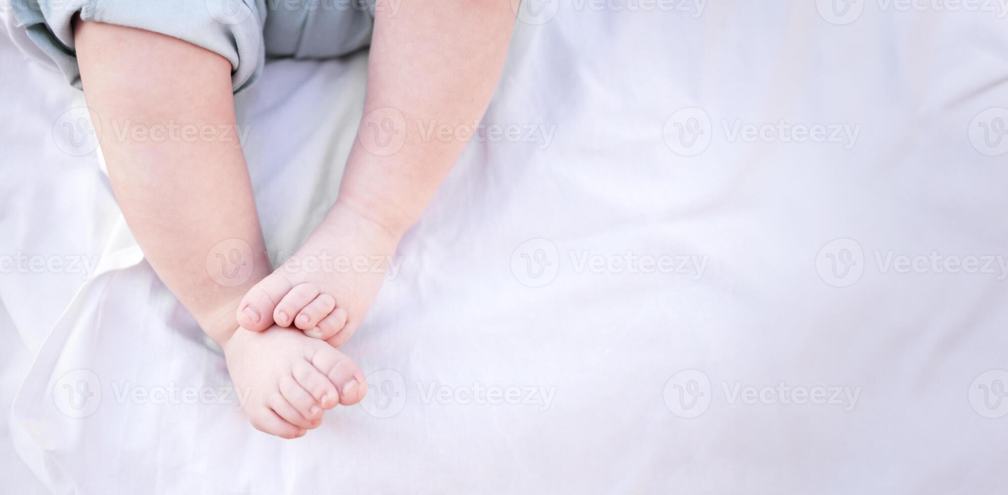 Legs close-up of newborn baby on light background photo