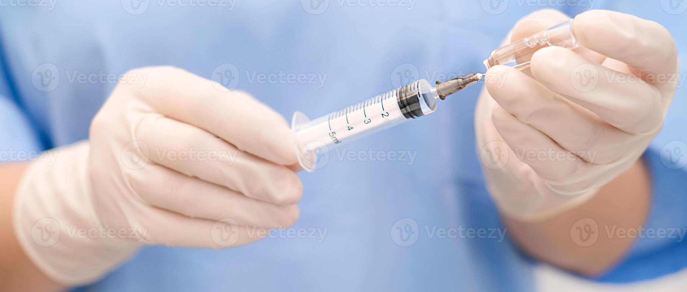 nurse draws medicine from an ampoule into a syringe photo