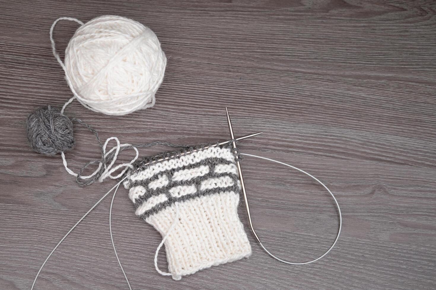 A ball of yarn with knitting needles on a light background photo