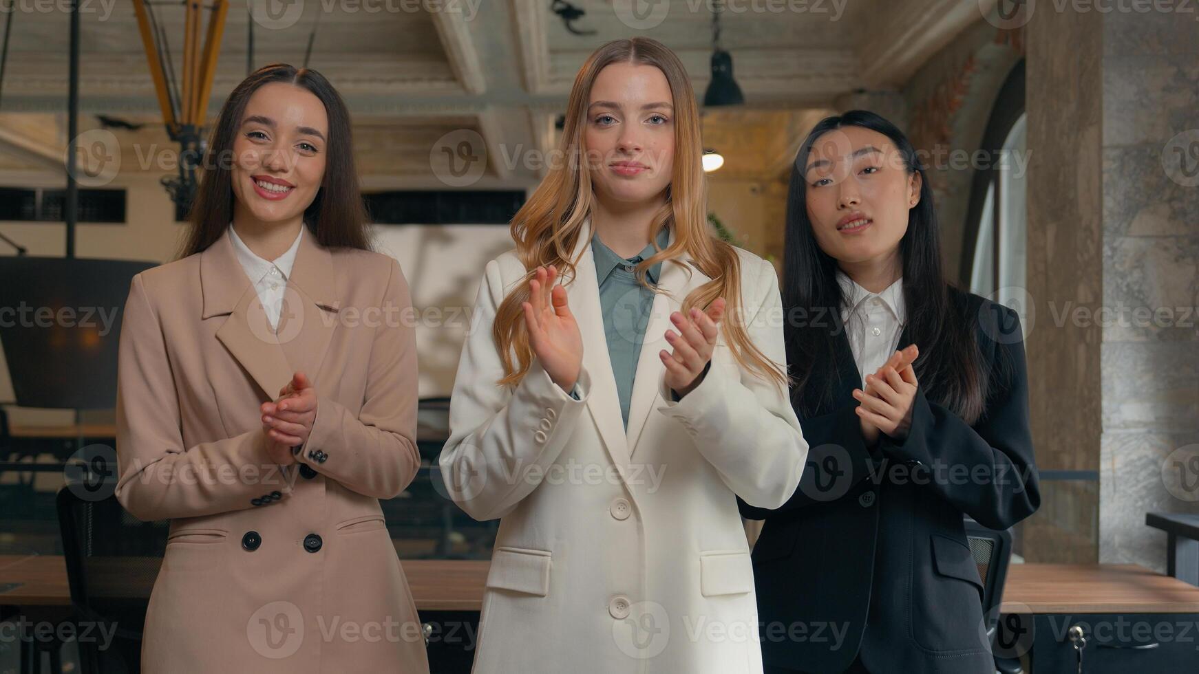 Smiling satisfied congratulation business multiethnic diversity women three multiracial females businesswomen Korean Asian Caucasian girls in office applauding clapping hands support applause feedback photo