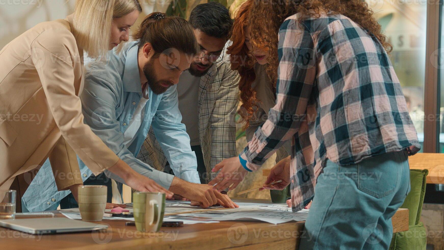 Office team multi ethnic designers male female group coworkers architects engineers constructors business men women discussing building plan construction blueprint chart architecture project on table photo