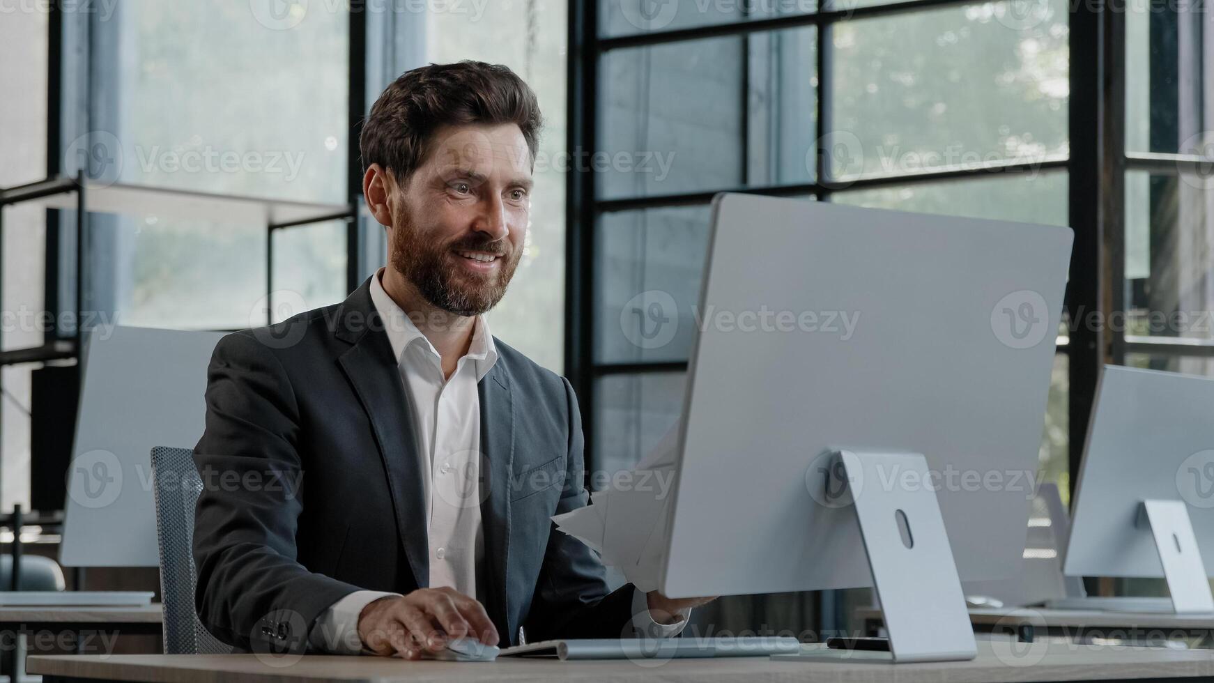 Caucasian 40s bearded boss investor entrepreneur employer man in office with computer looks at papers reads good news financial growth of business throws documents into air rejoices in winning triumph photo