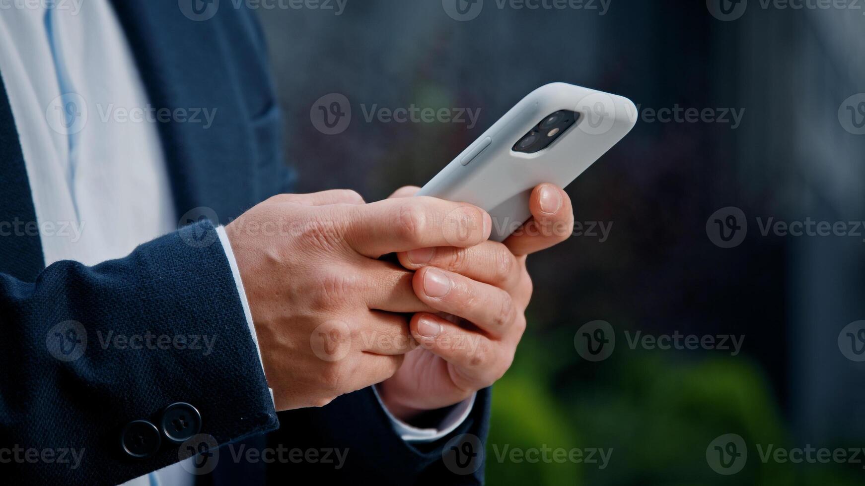Close up male hands typing texting browsing mobile phone. Unrecognizable unknown man businessman in formal suit working with smartphone in city outdoors manager managing project remote with telephone photo