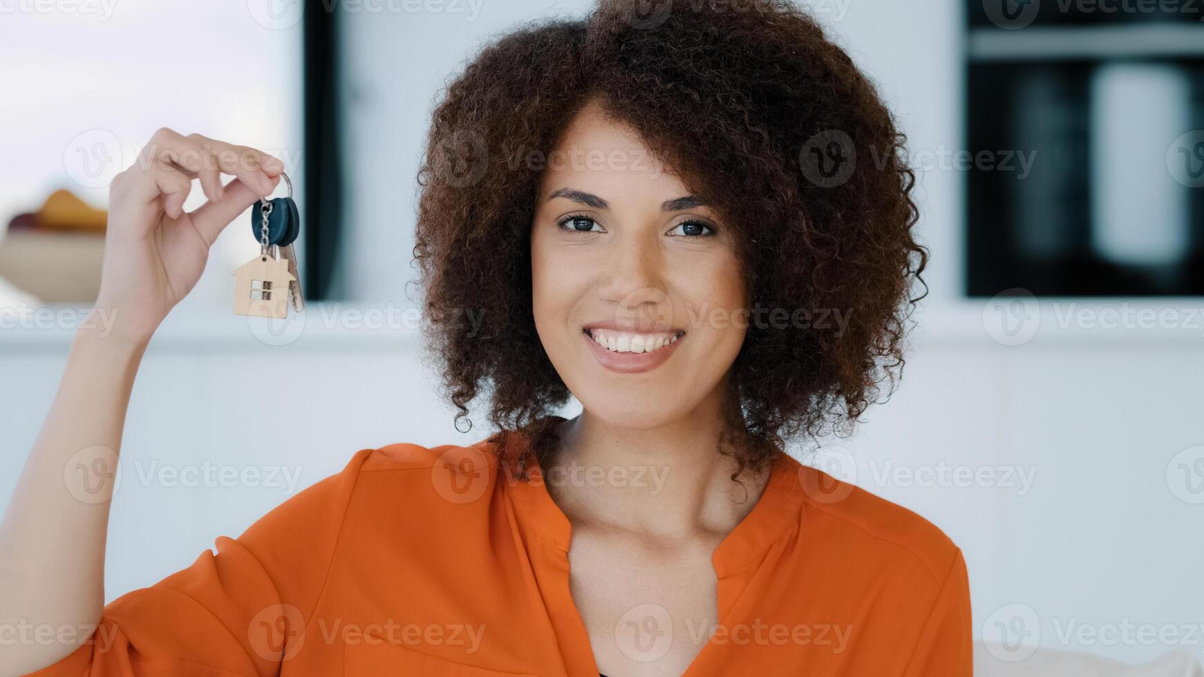 Portrait African exited woman looks at camera showing bunch keys celebrates success buying new home. Euphoric lady gets real estate opportunity rejoices apartment selling property dwelling relocation photo
