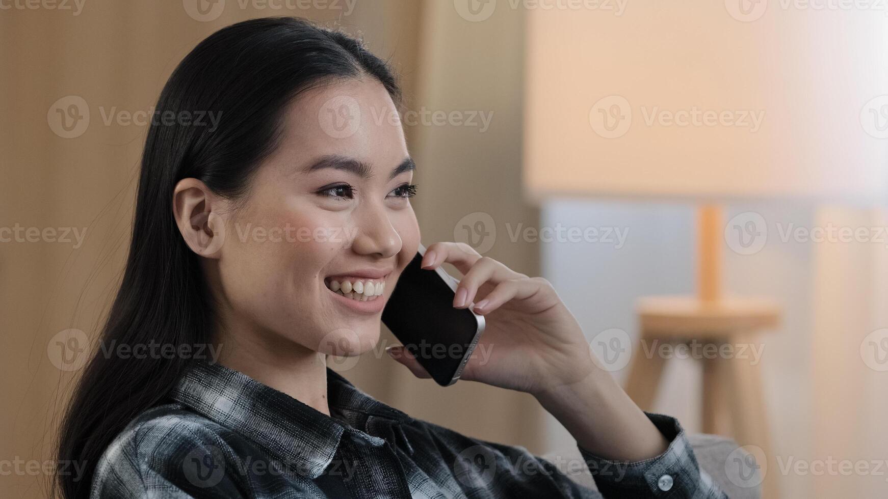 Smiling happy asian woman portrait girl smile speaking mobile phone at home. Close-up korean lady talking smartphone flirting on phone telephone listening good news remote discuss gossip with friend photo