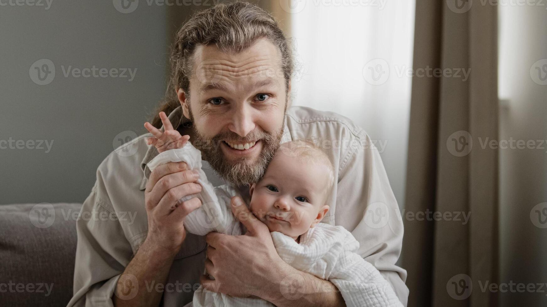 Webcam view portrait caucasian bearded dad and infant newborn small girl little kid daughter son waving hands greeting talking to camera call at home. Closeup father with little child conference photo