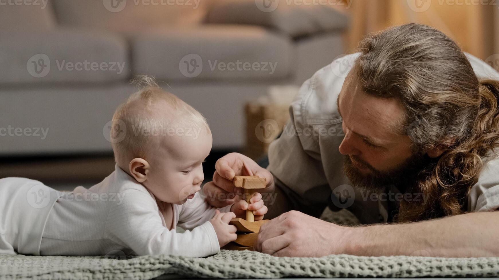 Caucasian family bearded father daddy dad with little daughter son baby infant newborn toddler playing at home on floor with toys collecting wooden constructor spend time together parenting concept photo