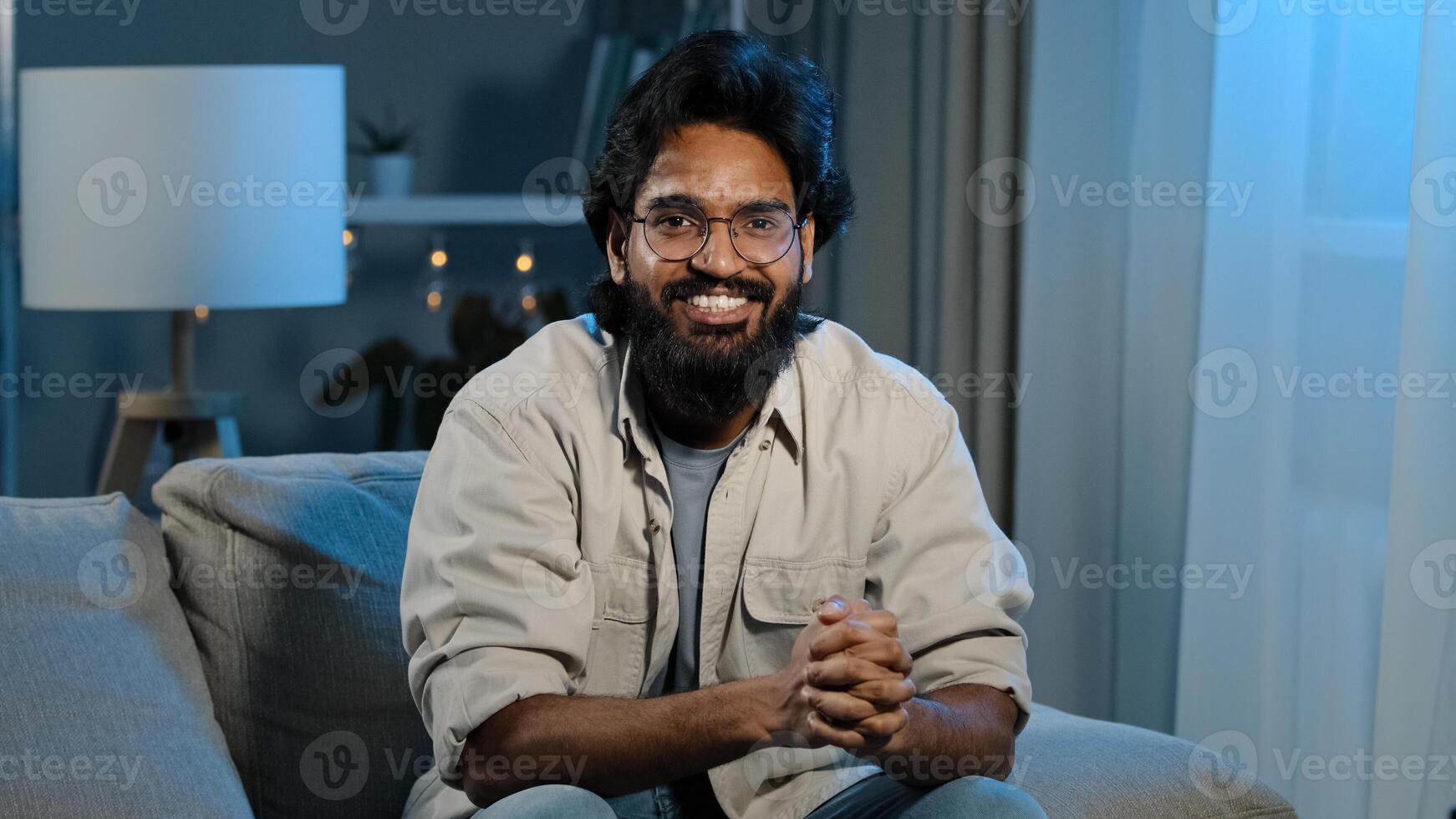 Close up happy indian arabian bearded man football male fan sitting at home evening at TV screen in dark living room and watching online match celebrating winning victory shout loud goal or win game photo