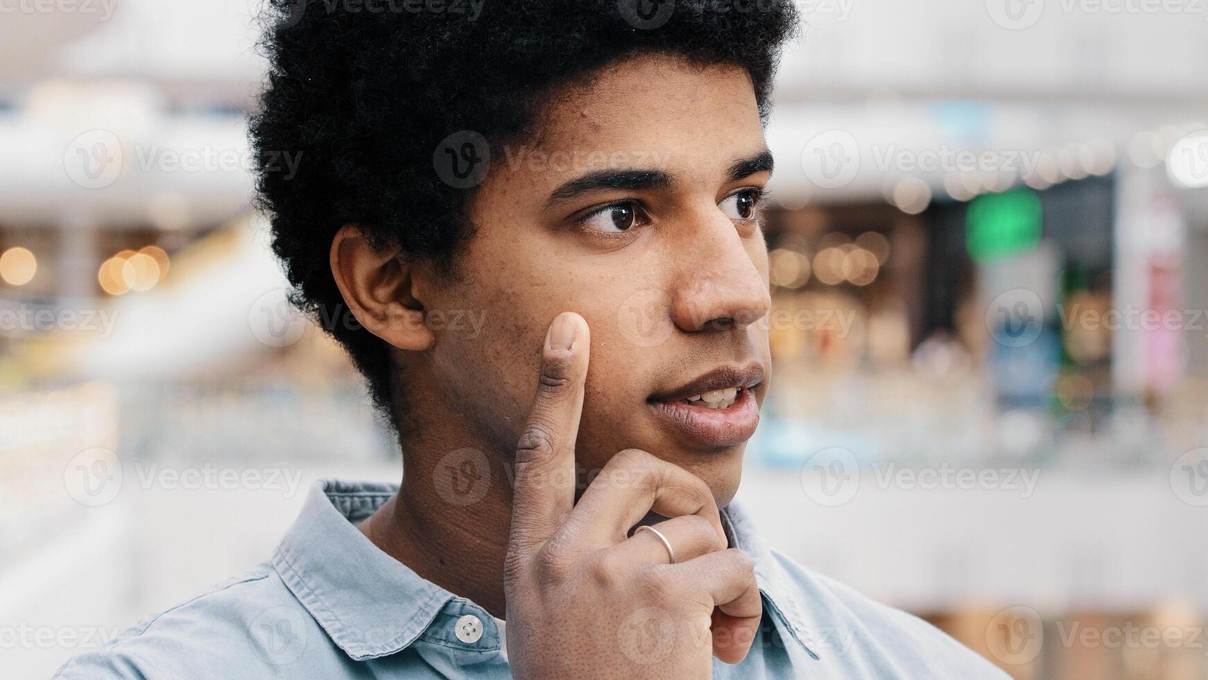Close-up male pensive face, portrait african american puzzled business man standing indoors deep in thoughts thinking recollecting memory creating plan happy raises index finger comes up with idea photo