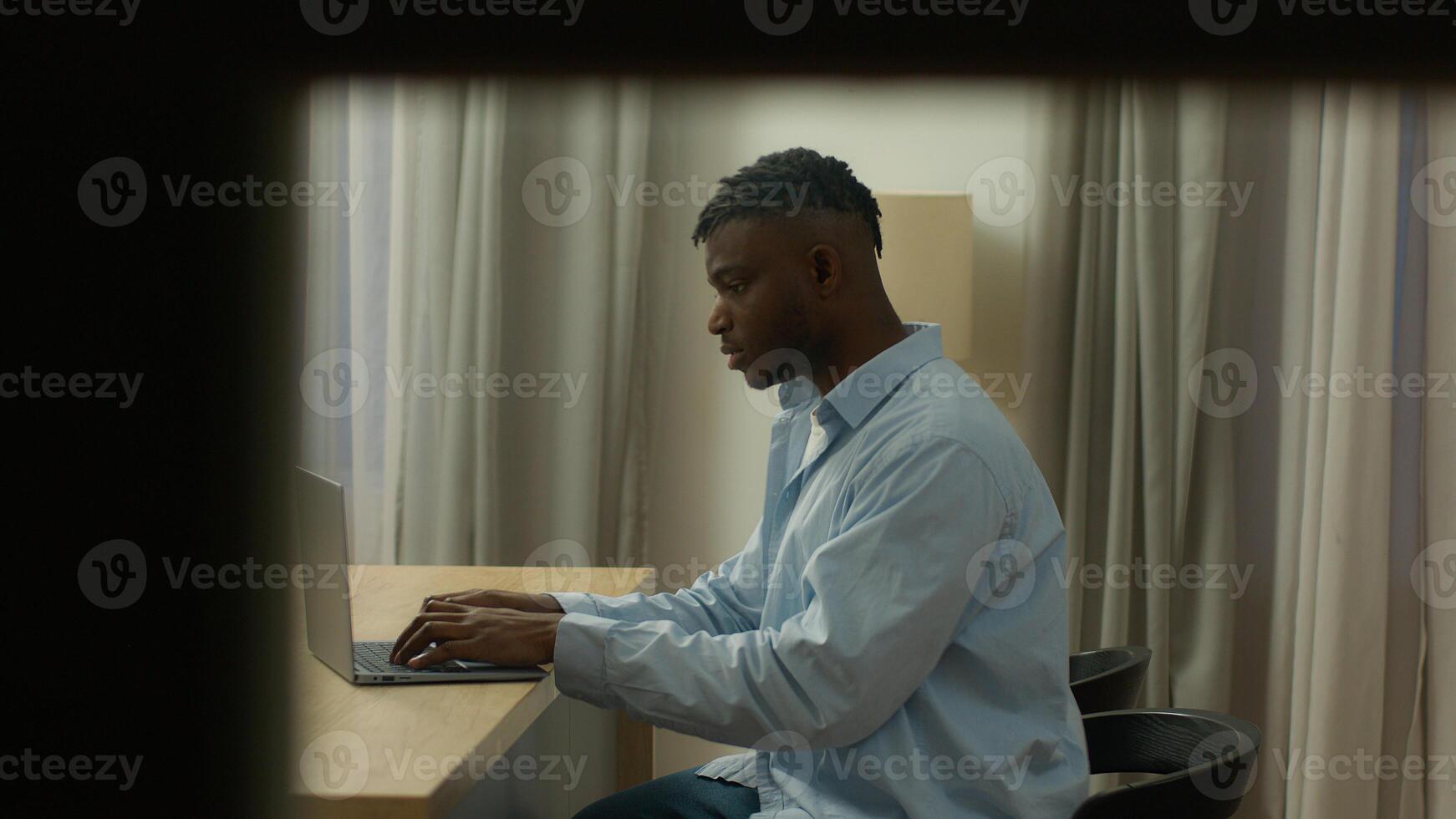 POV spy point of view African American man guy male user freelancer student business man working business late night evening at home thinking pensive typing laptop think solving problem author work photo