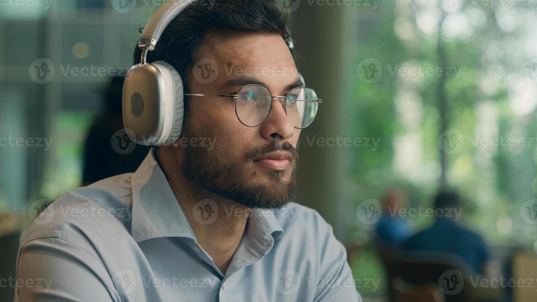 Arabian Indian business man ethnic happy smiling businessman male guy freelancer visitor in cafe restaurant turn music wireless headphones listen song audio in earphones enjoy sound relax drink coffee photo