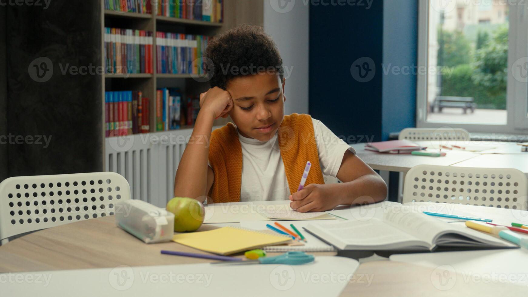 School classroom studying African American kid little boy son schoolboy pupil learner student tired sleepy child yawning learn lesson boring homework write test exam at desk study primary education photo