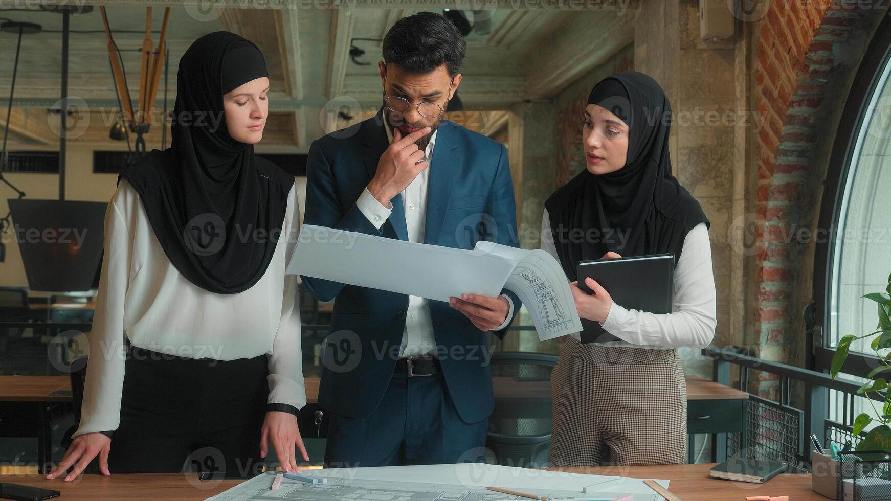 Arabian muslim man women in hijab architects engineers contractors designers business team in office displeased annoyed client check architecture blueprint construction plan problem building project photo