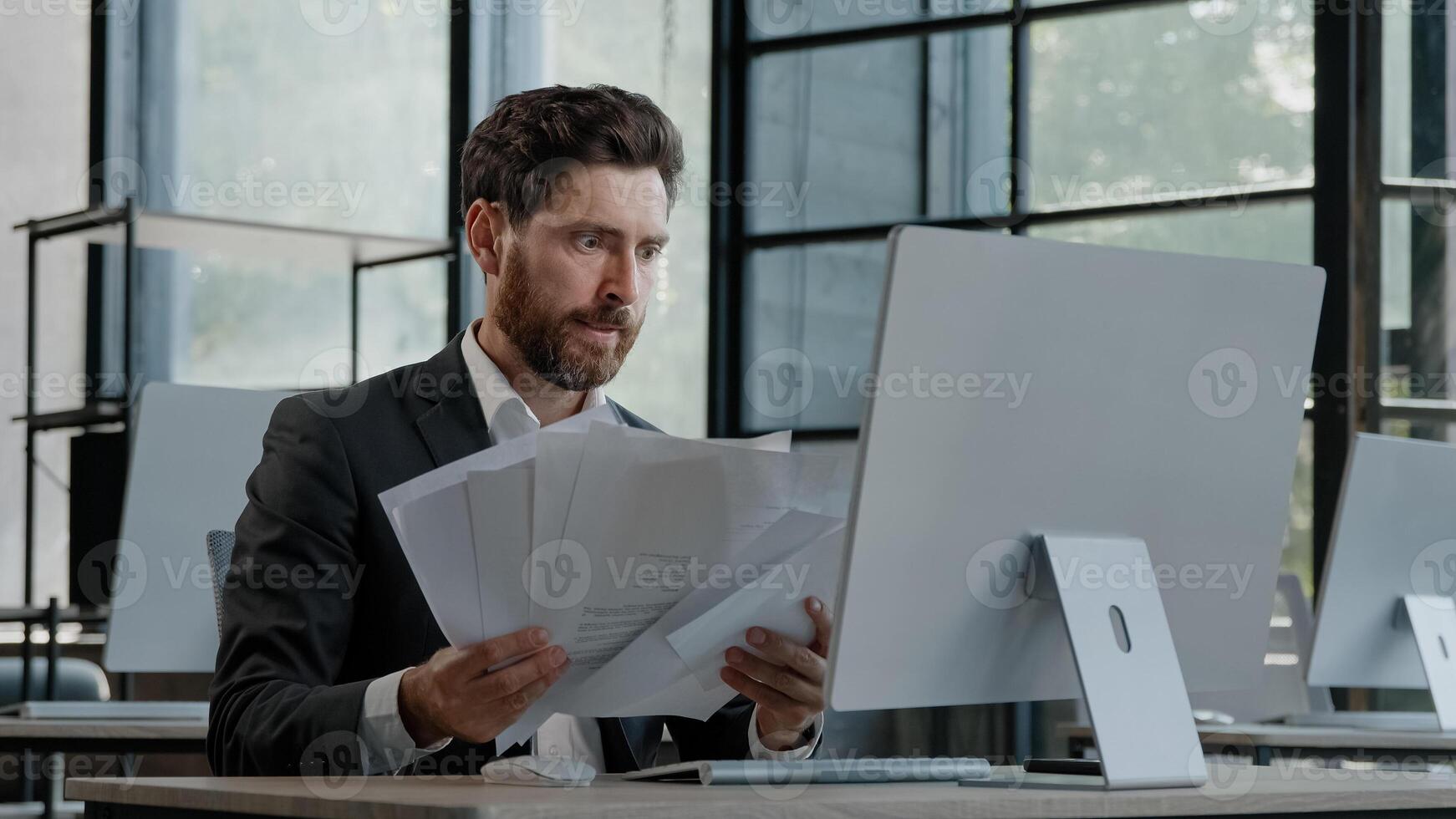 Upset tired exhausted burnout adult worker manager businessman sitting in office with paperwork difficult task incorrect data in papers and computer error throws documents holding head with sad photo