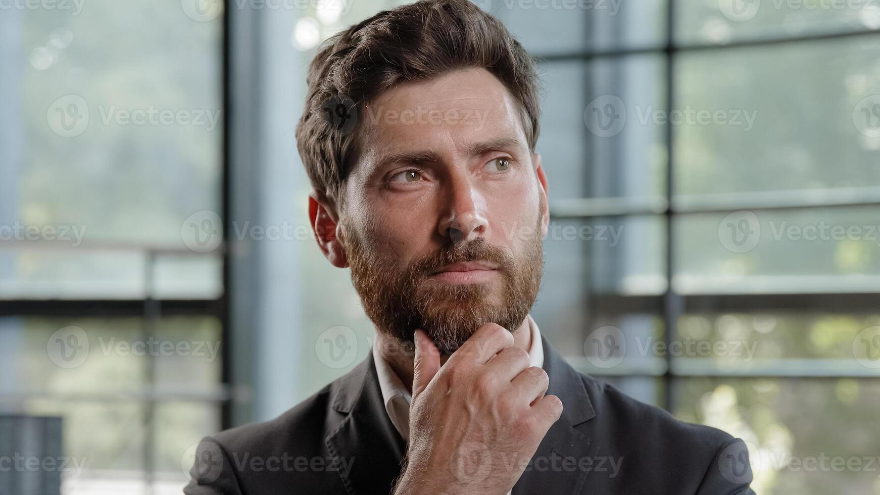 Pensive adult Caucasian bearded man 40s businessman posing looks around thinks pondering pensive thoughtful thinking about job project problem solutions comes up with ideas raised finger up in office photo