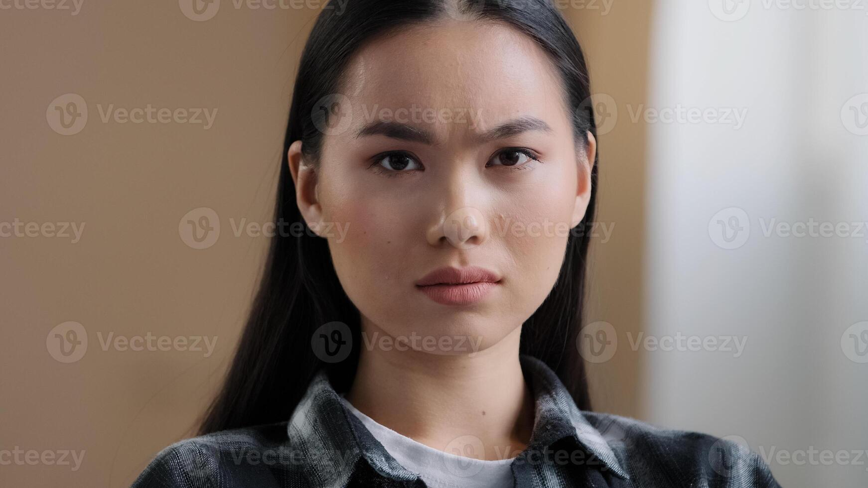 Female emotional portrait Asian girl shock surprise disappointment sadness bad mood negative reaction. Headshot Korean woman looking at camera with upset expression sad lady misunderstanding at home photo