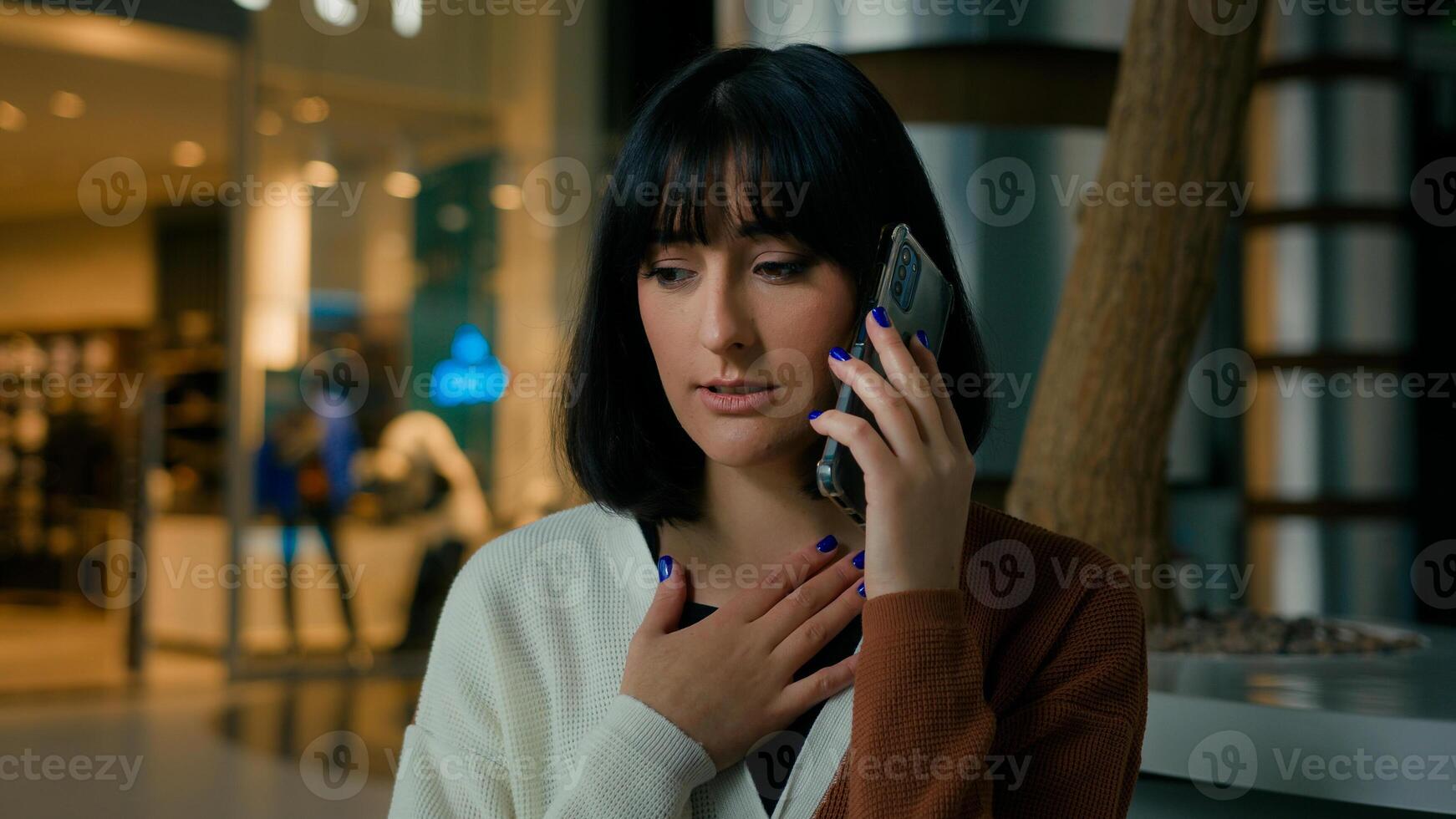 Worried upset woman indoors answer call talking phone disappointed shocked with smartphone conversation business problem lady speaking worry dissatisfied stressed female mobile talk trouble bad news photo