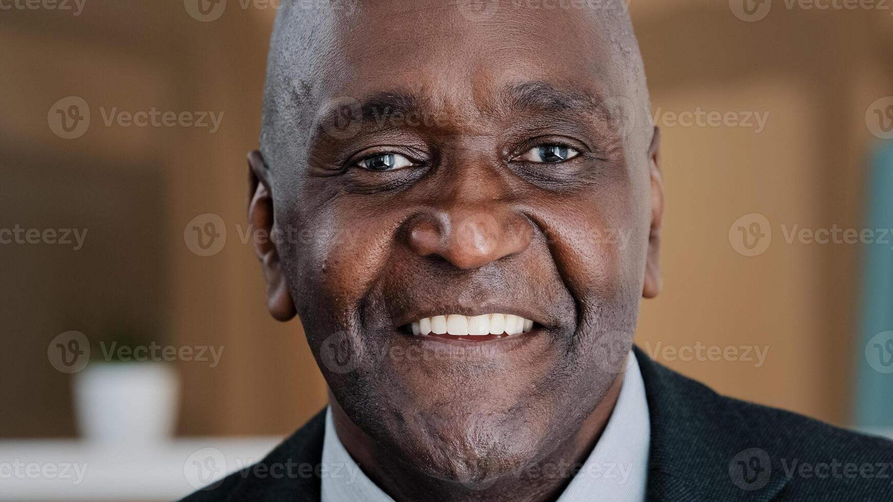 Close up happy male face 60s businessman elderly African American man grandpa satisfied client dentistry service ophthalmology clinic smiling toothy blinking mature senior citizen blink wink with eye photo