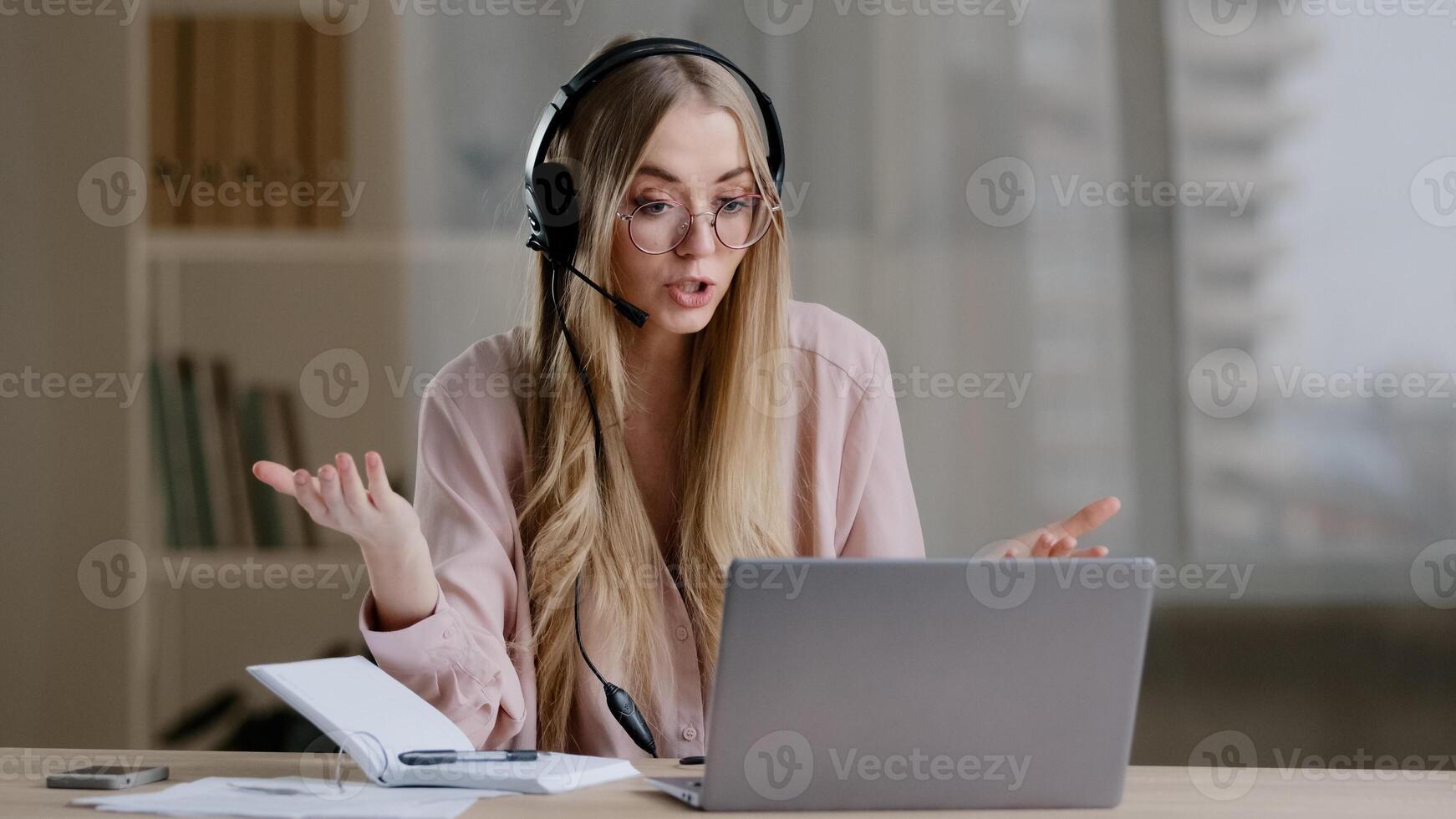 Millennial business woman online distant mentor in headset talking looking to camera showing explaining female professor teacher coach advisor helpline agent in headphone lesson call e-learning photo