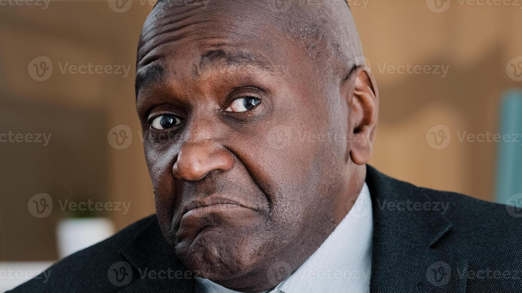 Extreme closeup old wrinkled emotional businessman African American scared shocked amazed biracial afraid mature 60s man shaking head no uncertain doubt reaction denial reject to question headshot photo