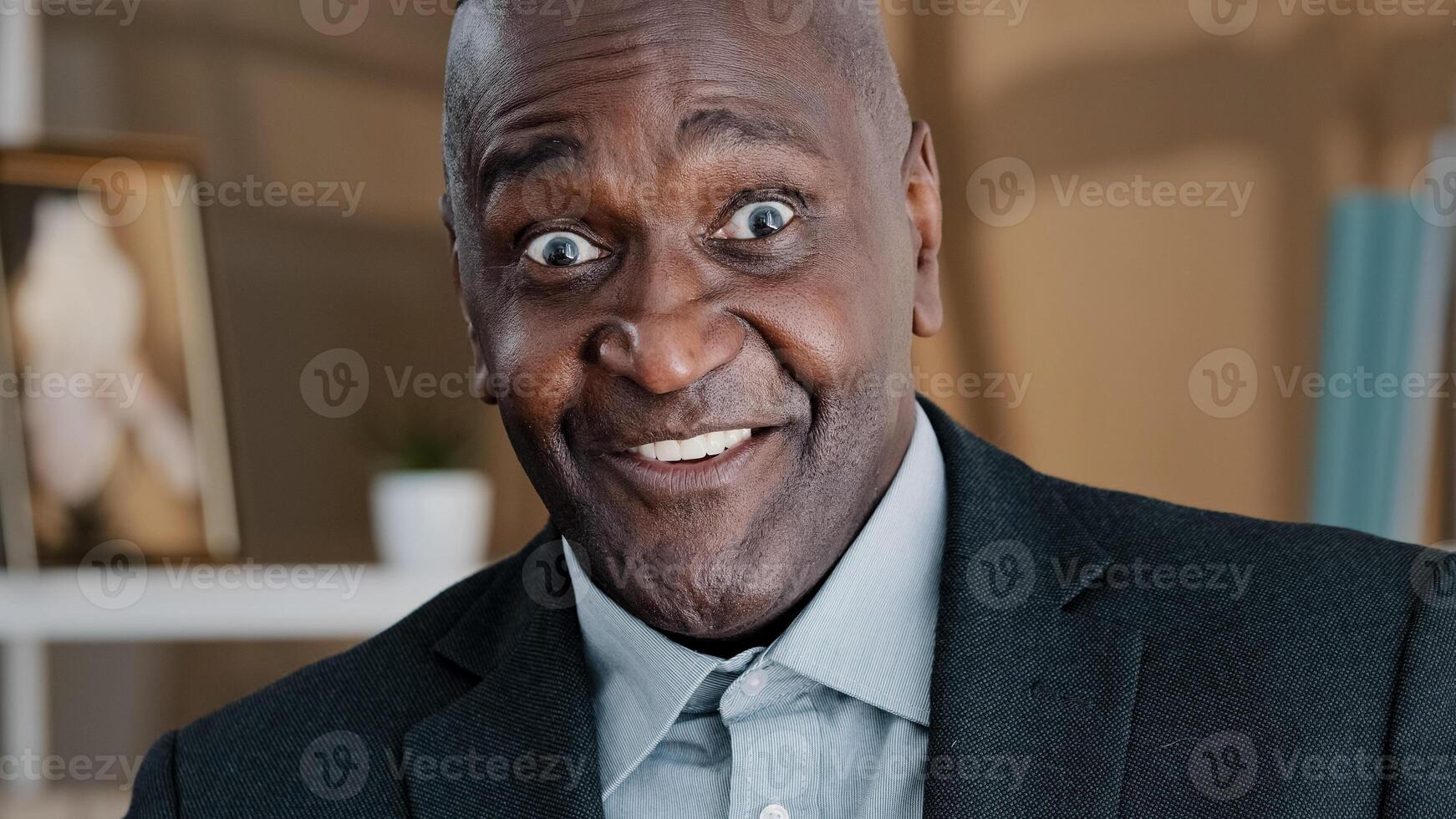 Close up old wrinkled male face surprised amazed African American man makes big eyes feels shock open mouth in astonishment wow reaction joyful happy amazed senior mature man hears good business news photo