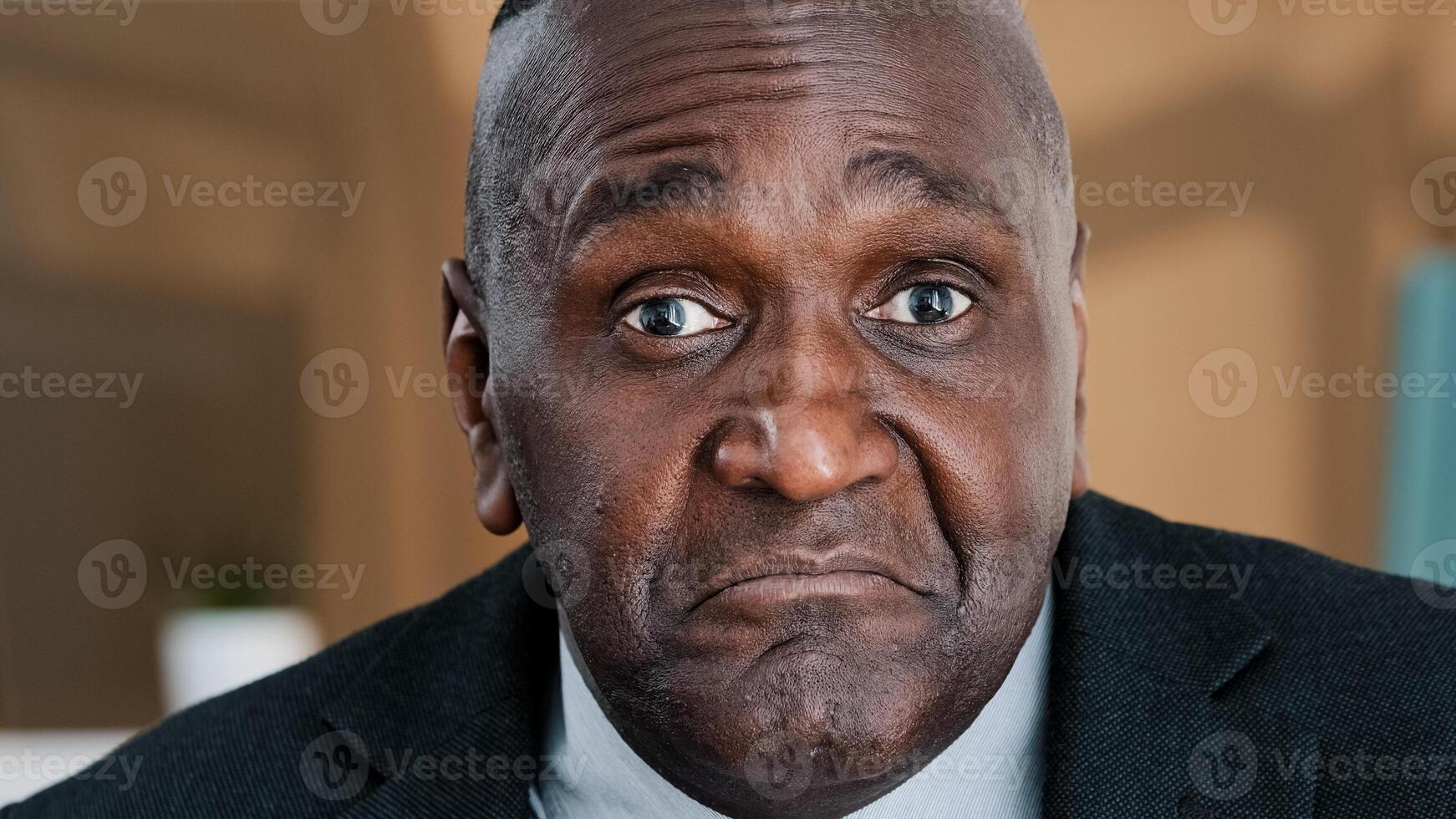 Extreme closeup old wrinkled emotional businessman African American scared shocked amazed biracial afraid mature 60s man shaking head no uncertain doubt reaction denial reject to question headshot photo