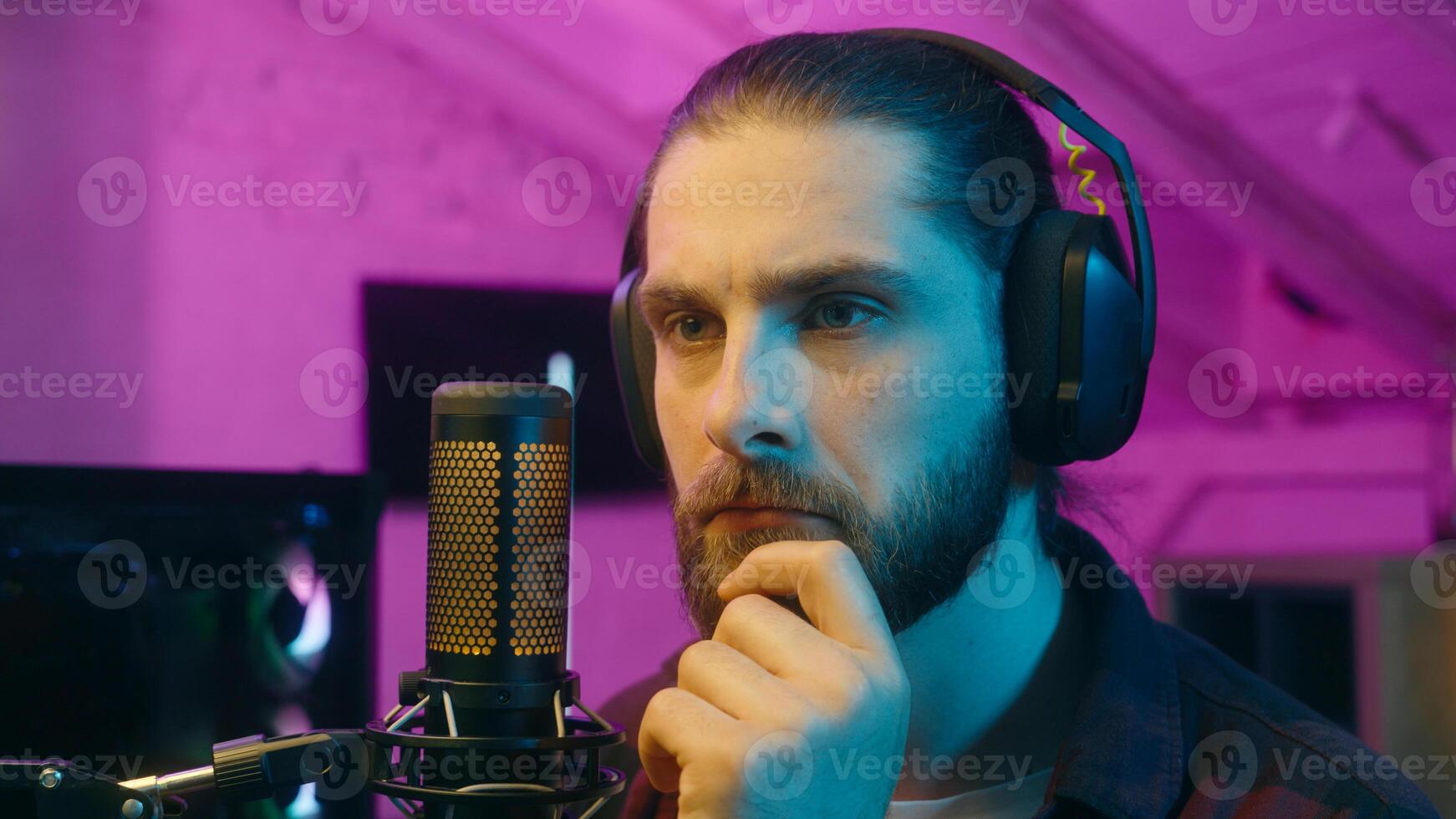 Puzzled thoughtful Caucasian influencer guy blogger player streamer man vlog contemplating cyber sport neon thinking gaming decision at home addict male gamer host play computer game blog idea thought photo