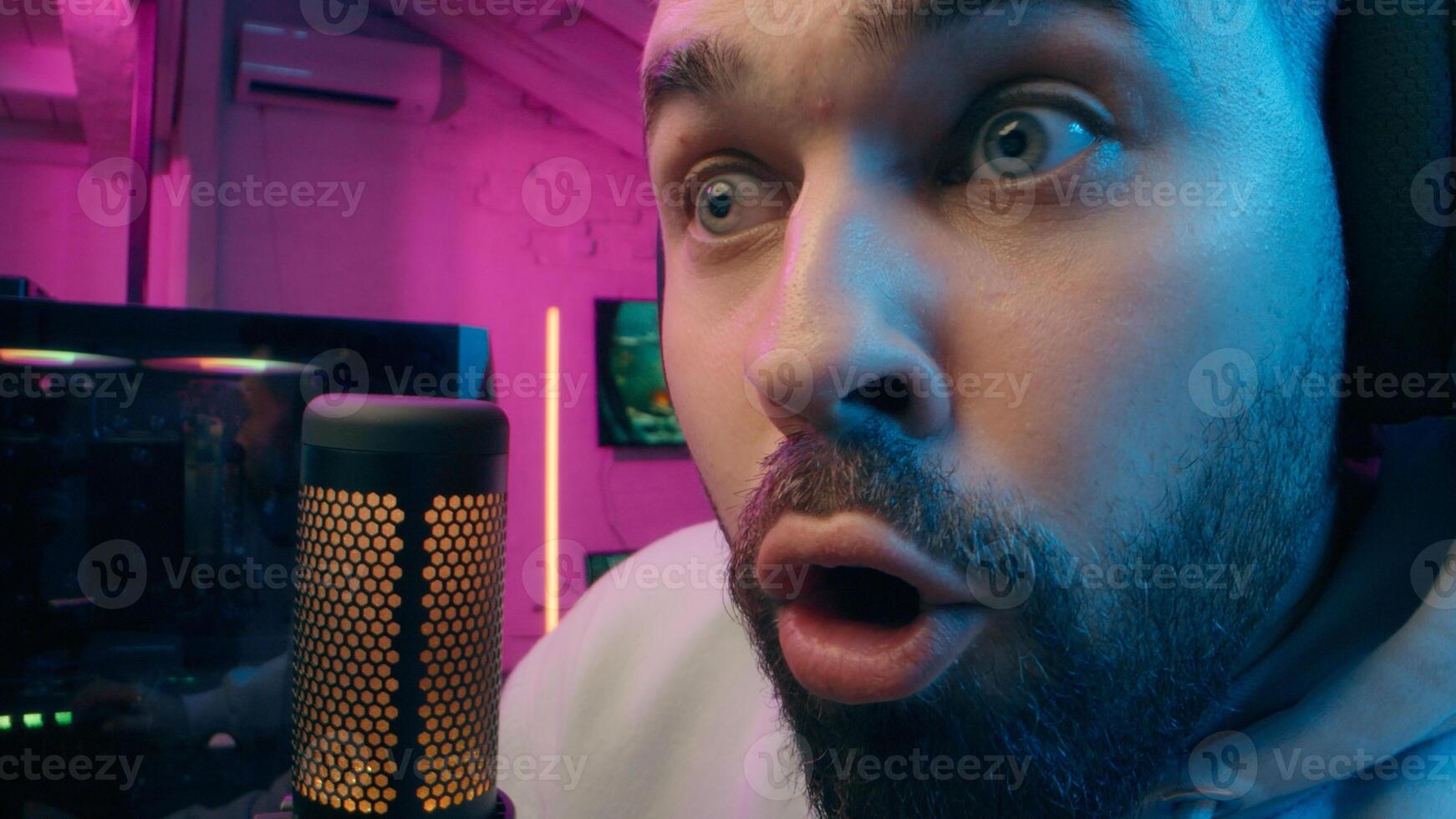 Astonished shocked Caucasian vlogger guy male laugh blogger influencer close up surprised man gaming addicted male streamer play cyber sport online game pc computer neon amazement wow emotion at home photo