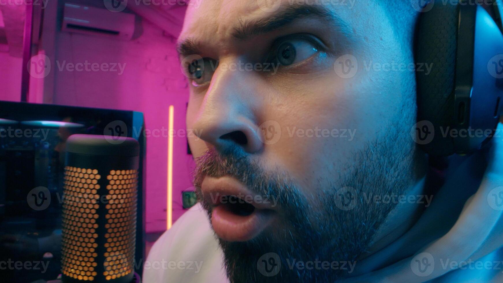 Astonished shocked Caucasian vlogger guy male laugh blogger influencer close up surprised man gaming addicted male streamer play cyber sport online game pc computer neon amazement wow emotion at home photo