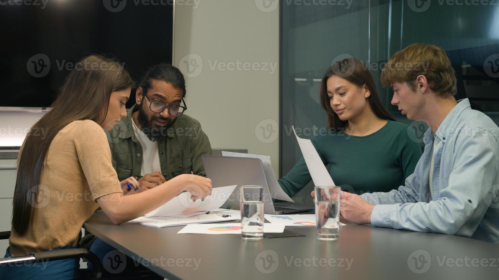 Diverse businessmen businesswomen team review sales data documents paperwork teamwork discussion multiracial business men women colleagues coworkers company brainstorm talk at table in conference room photo