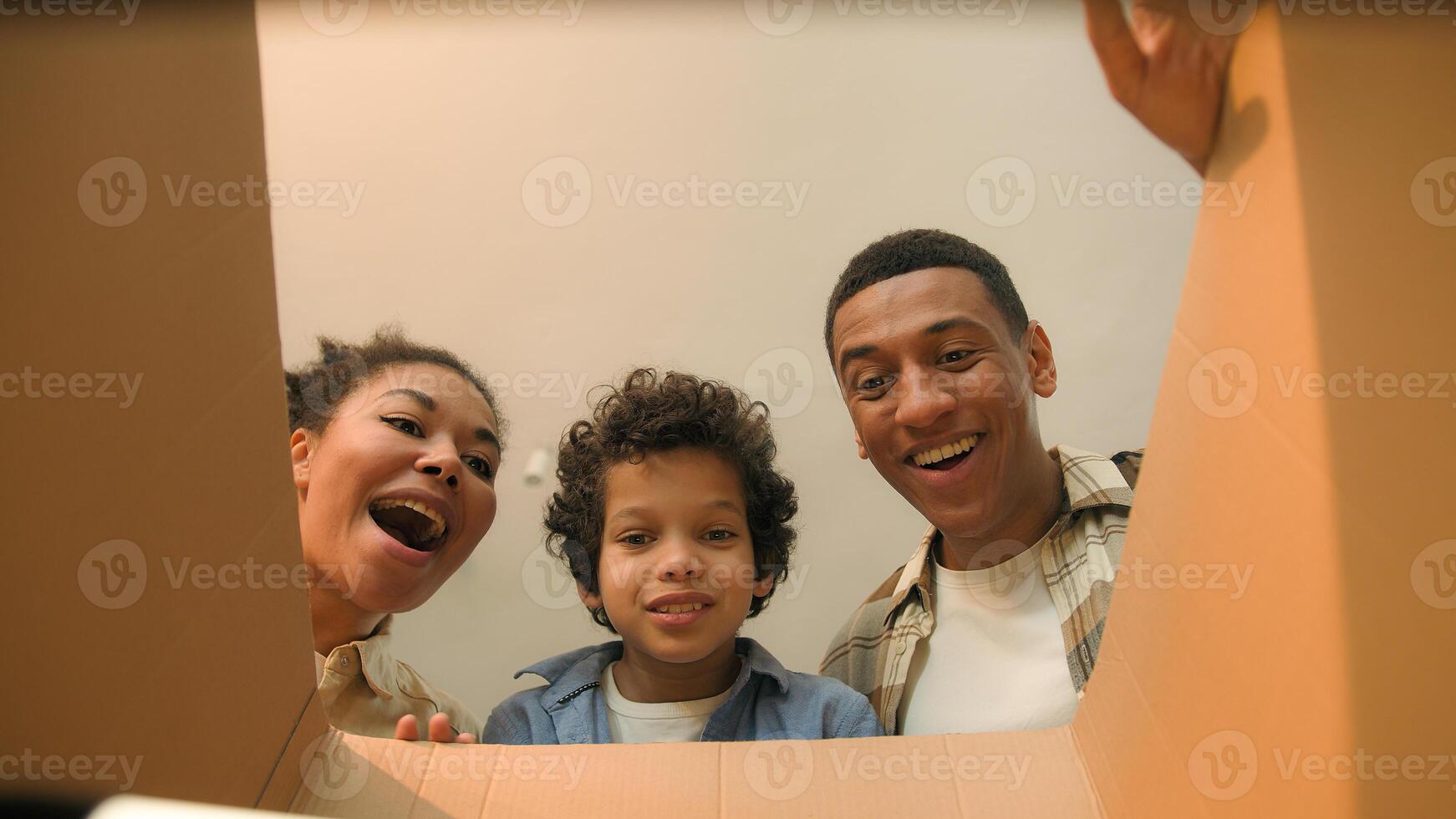 Point of view POV opening inside cardboard box happy surprised joyful African american family parents son little boy child kid order delivery unboxing unpacking parcel online shopping store moving day photo