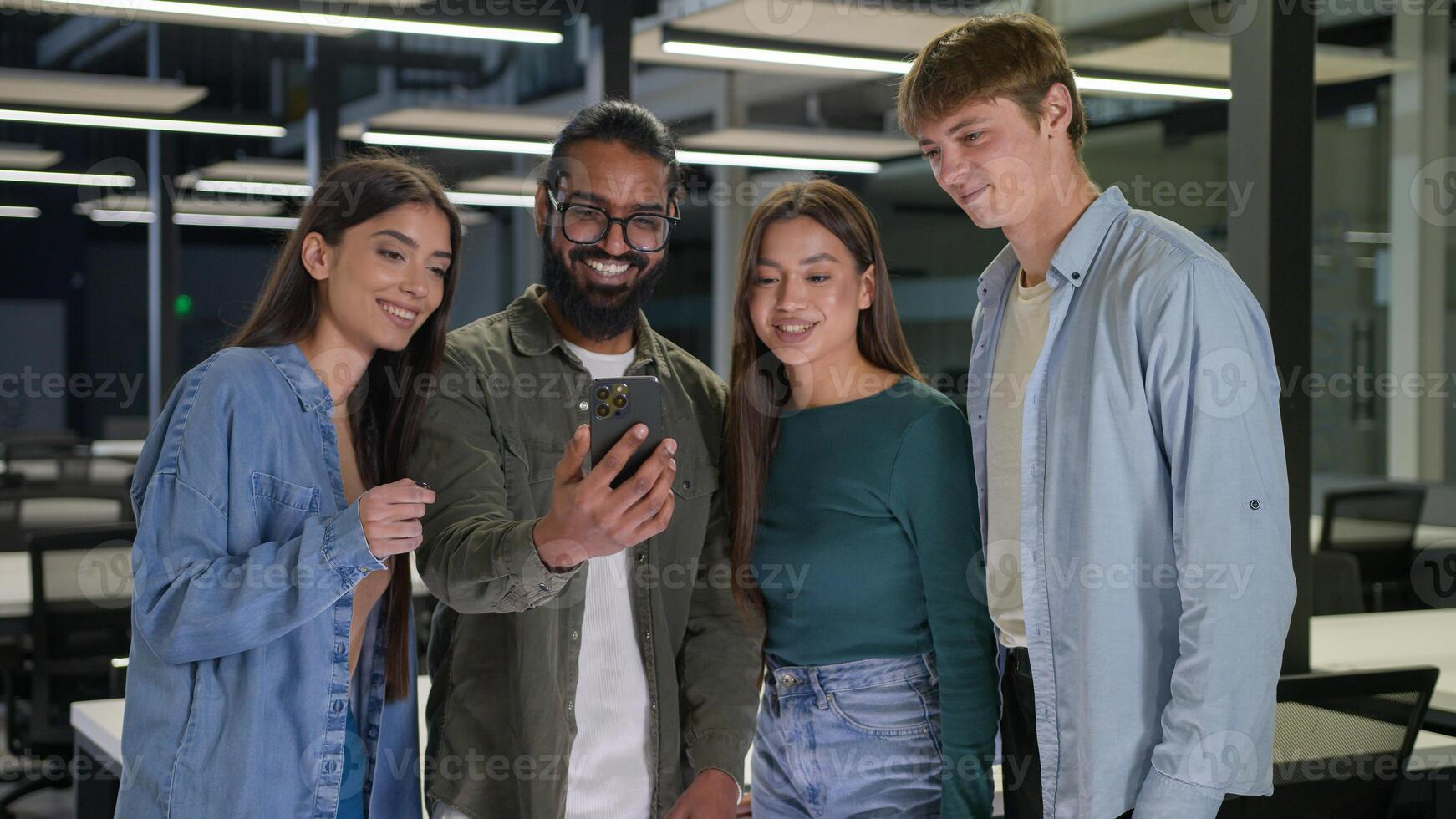 Diverse multiracial business people women men students group friends look screen mobile phone happy cheerful smiling businessmen businesswomen using smartphone in office discuss good news team project photo