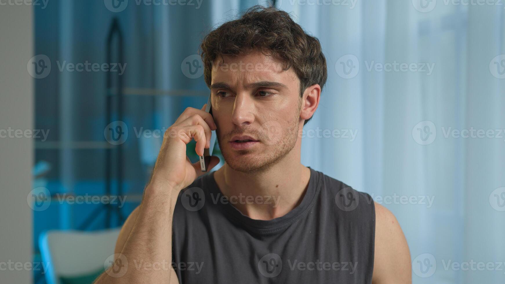 Caucasian man athlete talking mobile phone smartphone call sport guy male sportsman technology telephone anger annoyed frowning unhappy dissatisfied displeased home training problem communicate gadget photo