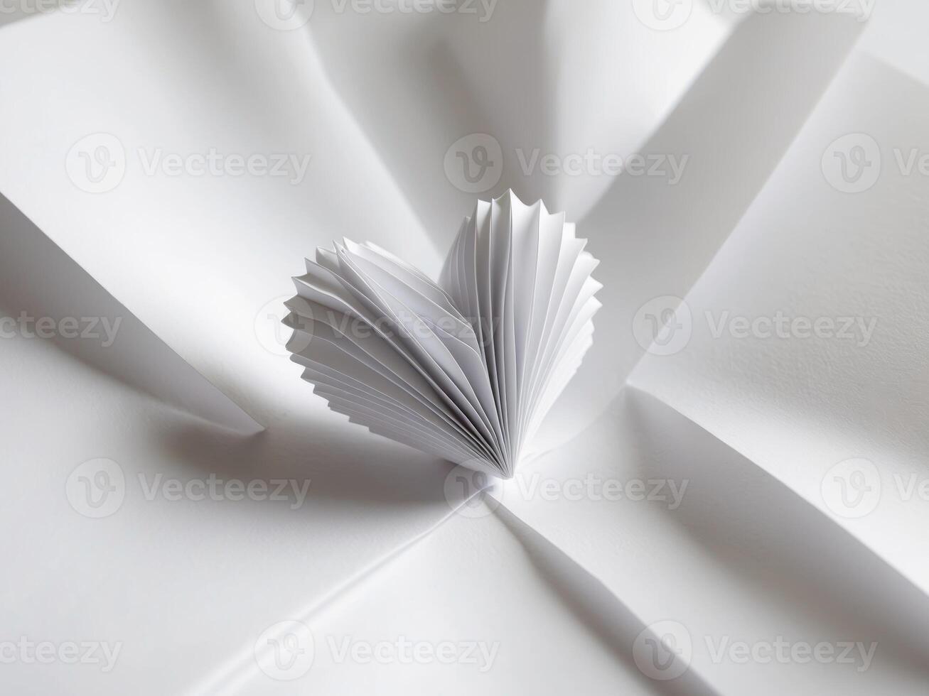 A heart made of paper is surrounded by white paper photo