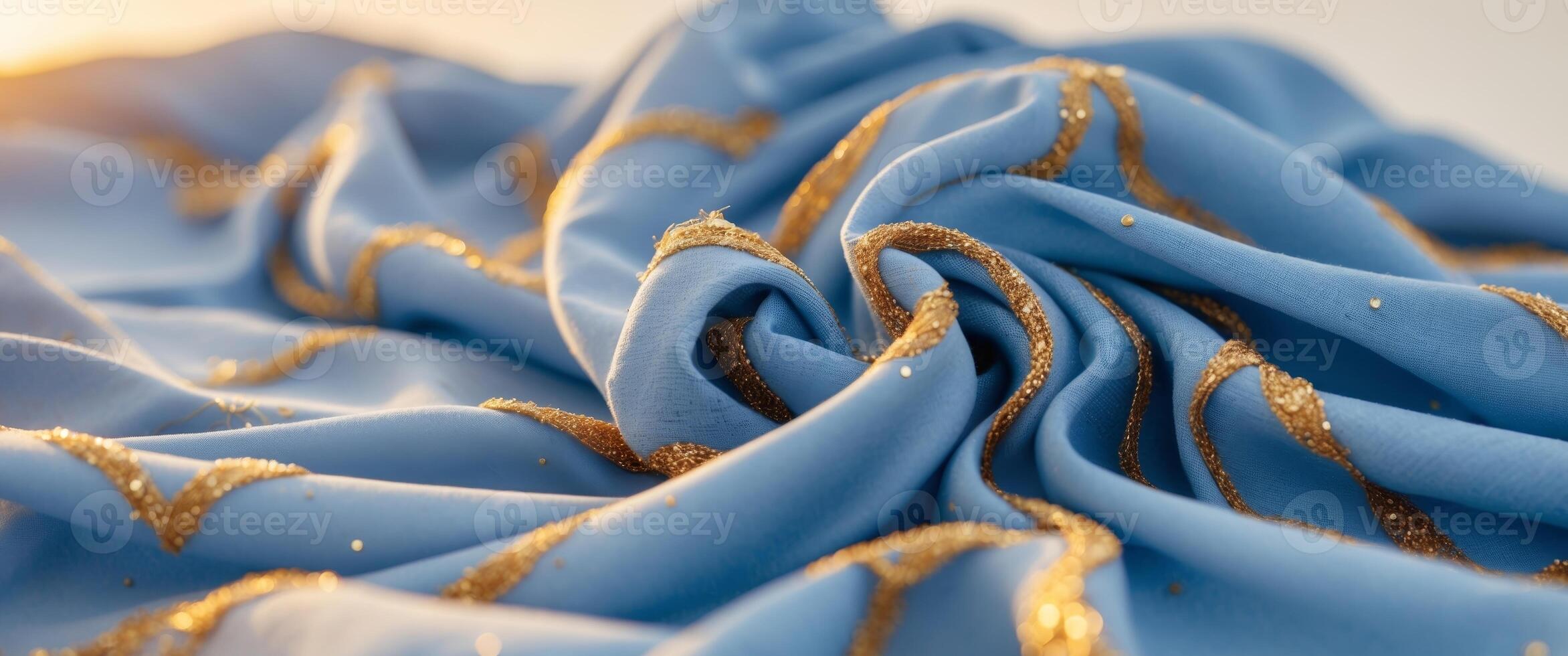 Elegant blue fabric with golden accents illuminated by warm sunlight at dusk photo