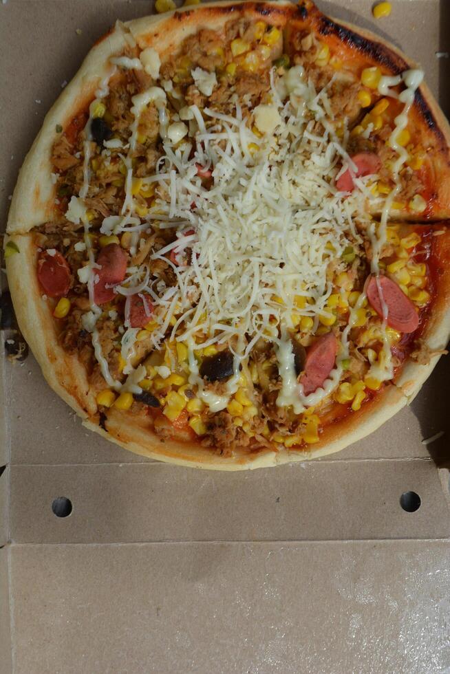 Delicious pizza with topping sausages, cheese, and corn, delicious meal to eat photo