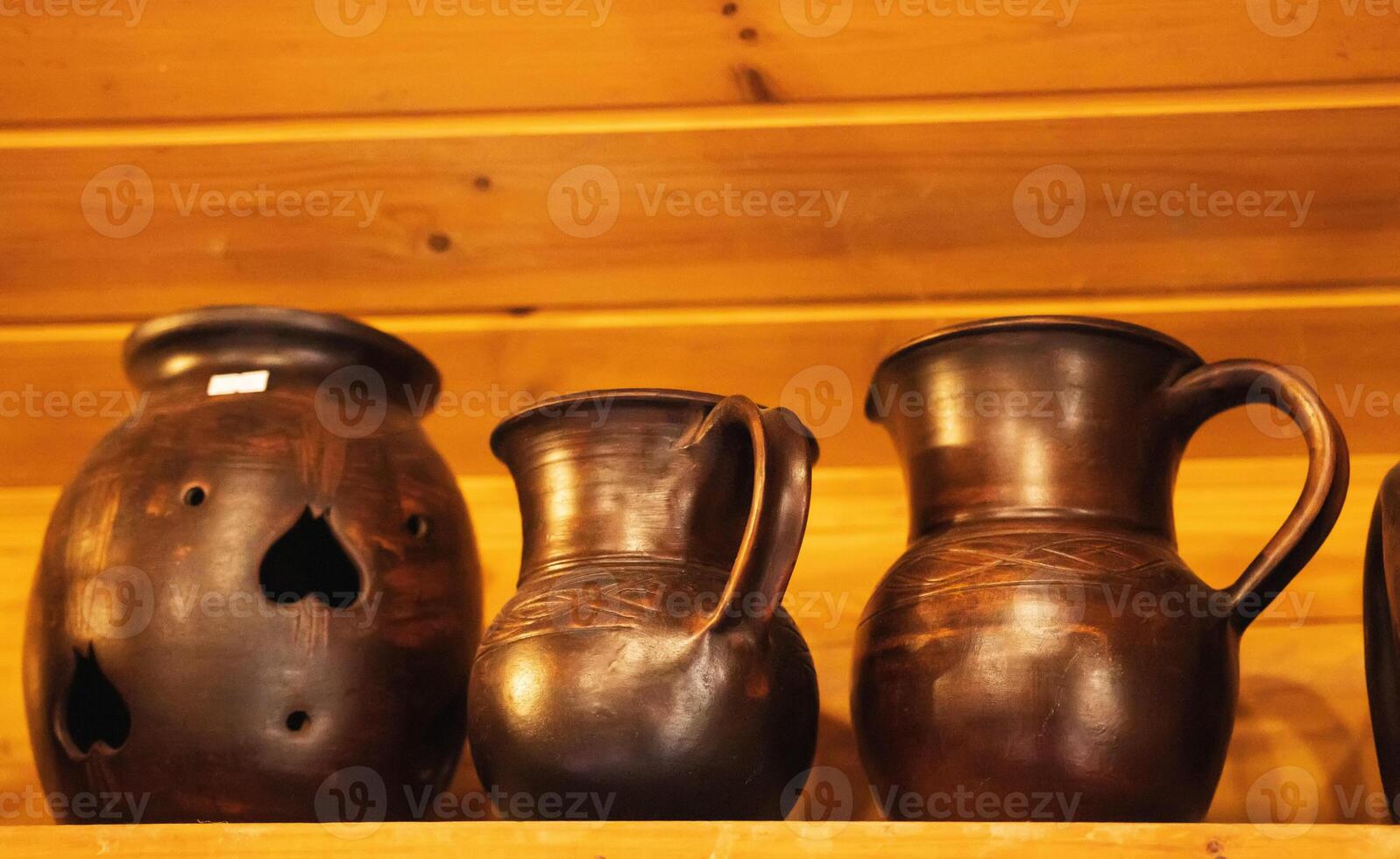 Beautiful brown earthenware jugs stand on a shelf. Ware from ceramics and clay. photo
