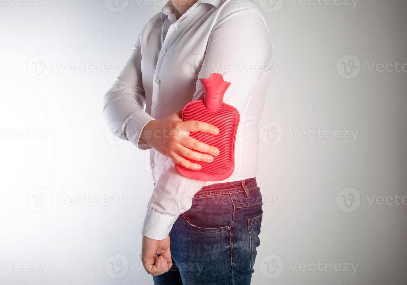 Treatment of arthritis of the elbow joint with a heating pad with hot water. Heat therapy, painkiller photo