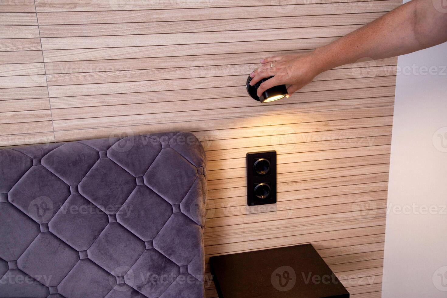 Adjustment of the rotary lamp at the head of the bed in the bedroom. photo