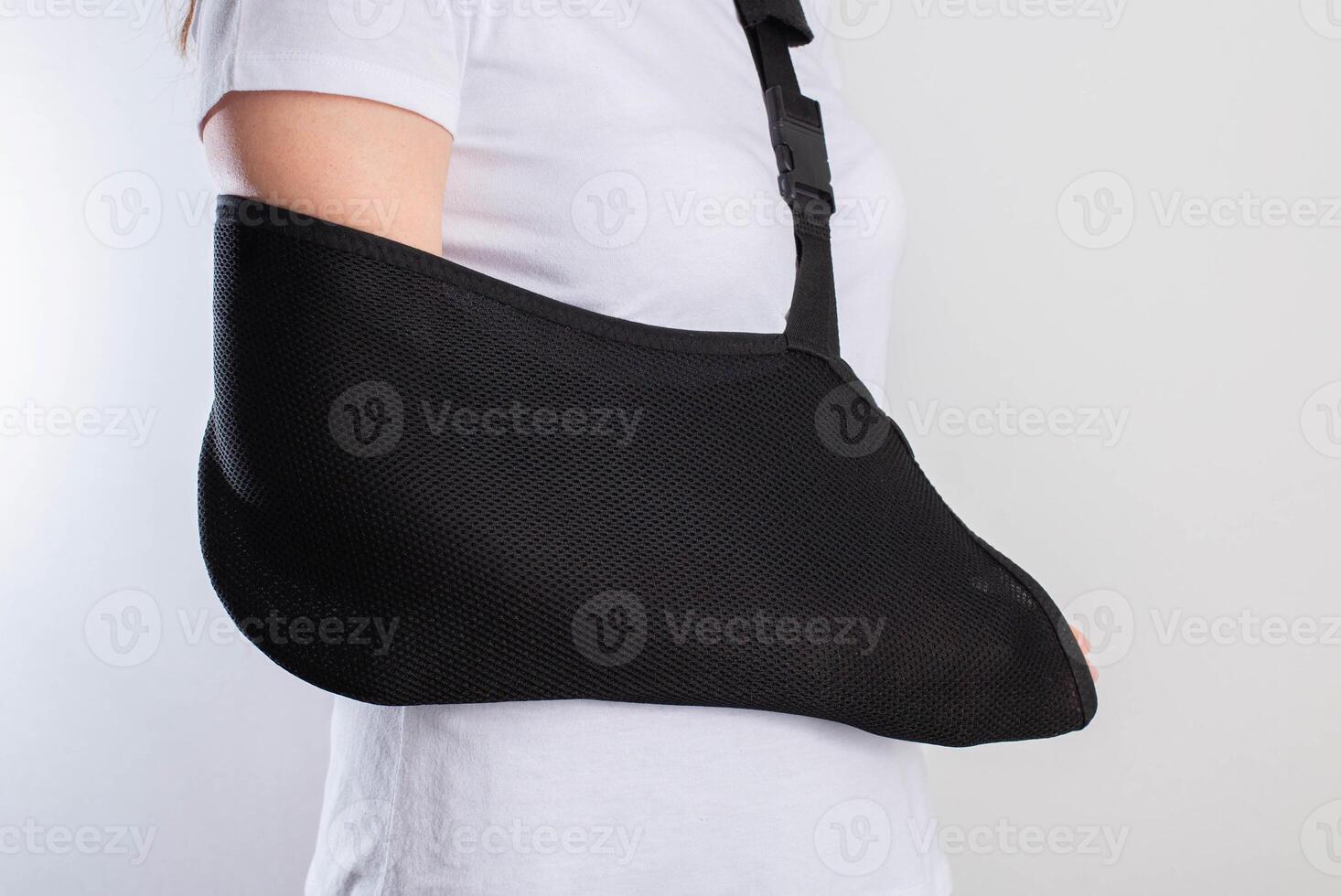 A girl's arm in a black support bandage after a broken arm and sprained shoulder joint. Rehabilitation after injury, close-up photo