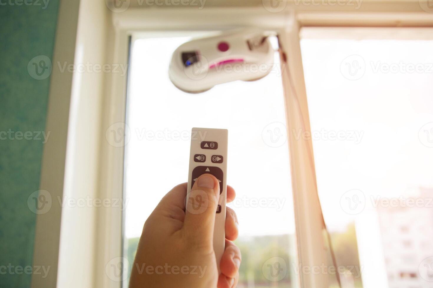 Remote control of a robotic window washer that washes glass from dirt and stains. Copy space for text photo