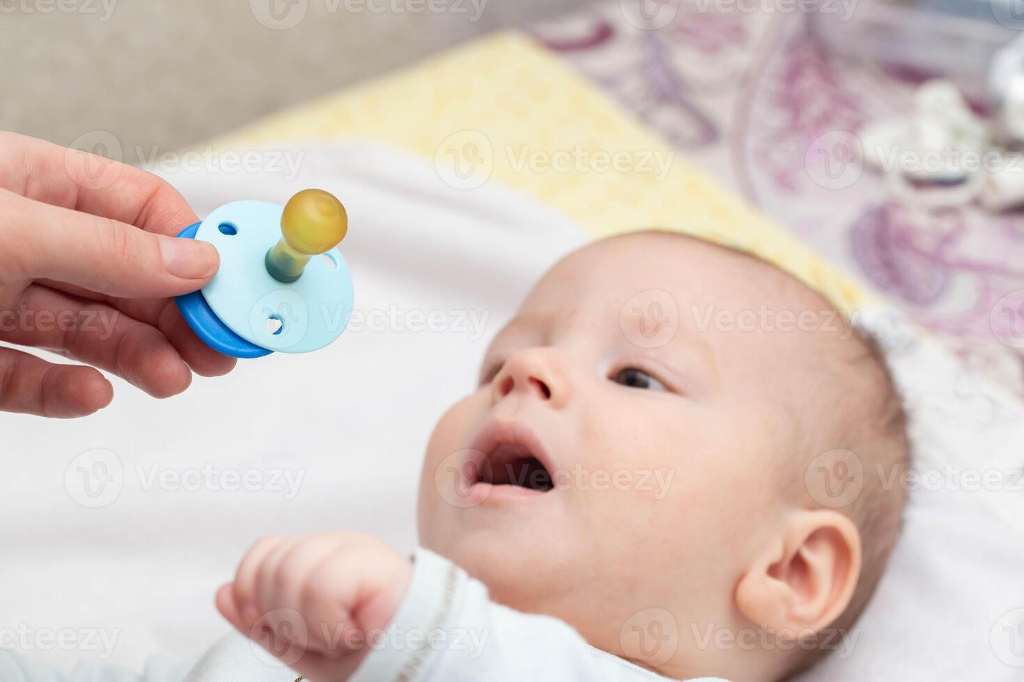 Little caucasian baby boy and pacifier. The habit of the sucking reflex in infants. photo