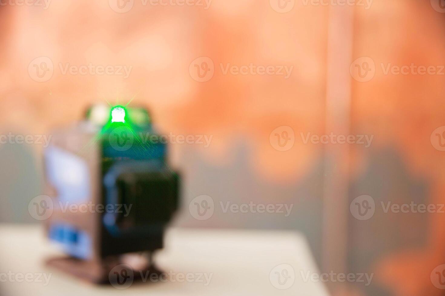 Modern laser level on the background of walls with concrete contact. Copy space for text photo