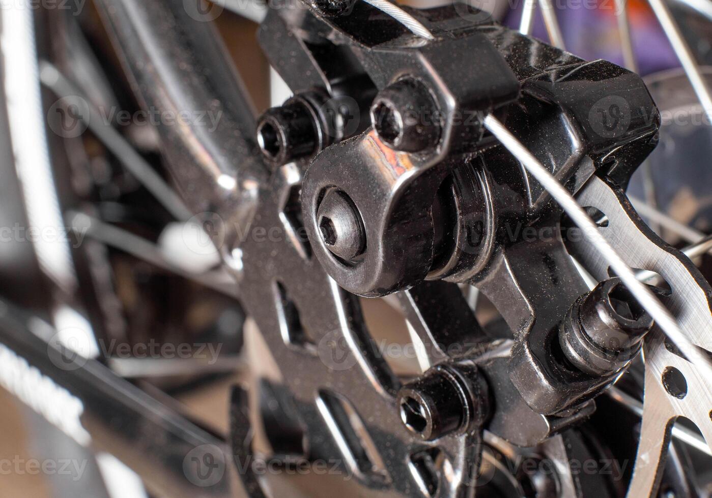 Brake system of a caliper and a metal brake disc on a bicycle, background, macro photo