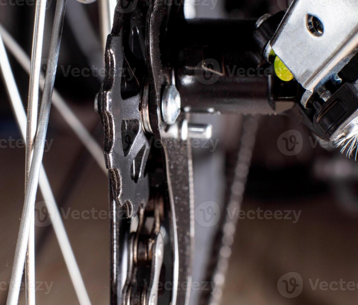 Gearshift on mountain bike MTB, chain moves on rings. Changes speeds. Shift gears on bicycle crank. Work of chain drive chainset. Front derailleur. Macro closeup low angle shot. Wheel spins and turns photo