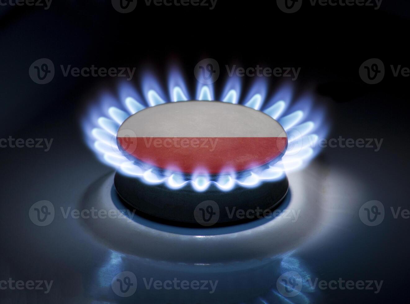 Burning gas burner of a home stove in the middle of which is the flag of the country of Poland. Gas import and export delivery concept, price per cubic meter, transit, background photo