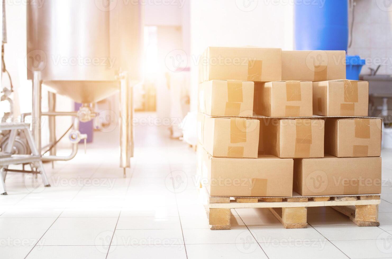 Boxes on a pallet with sugar products against the background of production equipment. Sugar beet sugar manufacturing concept, copy space photo